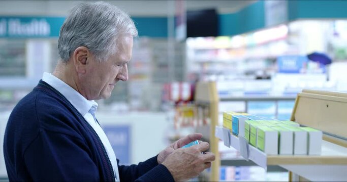 Senior pharmacy customer shopping shelf medication in medical drugstore, retail service and store for wellness treatment choice. Man reading box label of healthcare medicine, brand product and pills