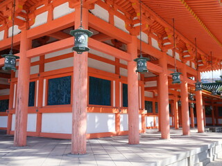 vermillion painted shrine with lanterns hanging at heian jingu in kyoto on a bright sunny day