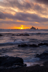 Sunset with sea stacks and a rocky beach at low tide at Rialto Beach in Olympic National Park

