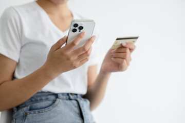 Close-up shot of Asian woman using smartphone and credit card at home online shopping concept.