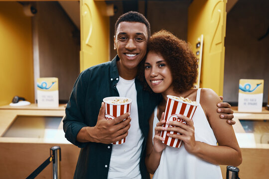 A couple buys a movie ticket at the box office.