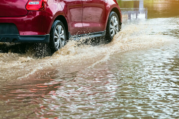 Car passing through a flooded road. Driving car on flooded road during flood caused by torrential...