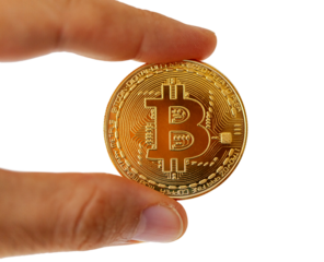 A Bitcoin coin between the  fingers. Subject isolated on white background.