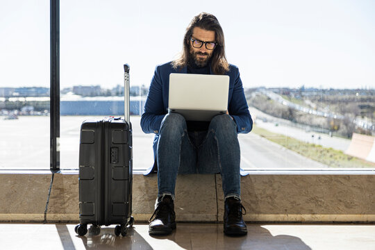 Busy man using laptop in airport lounge