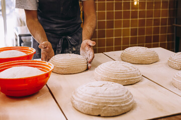 Crop male cook shaping dough with proofing basket