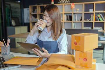 young businesswoman using tablet computer online chat with packaging box, Business online influencer on social media concept, Online Selling, Online Shopping to market.