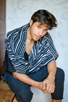 Stylish Hispanic model with clasped hands at home