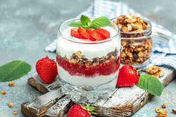 Parfait Greek yogurt with fresh strawberry and granola on a wooden board. gluten free diet, Healthy breakfast. banner, menu, recipe place for text, top view