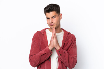 Young caucasian man isolated on white background keeps palm together. Person asks for something