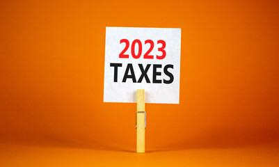 2023 taxes new year symbol. White paper with words 2023 taxes, clip on wooden clothespin. Beautiful...