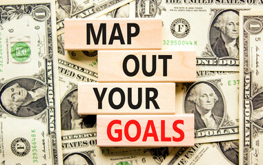 Support and map out your goals symbol. Concept words Map out your goals on wooden blocks on a beautiful background from dollar bills. Business, support and map out your goals concept