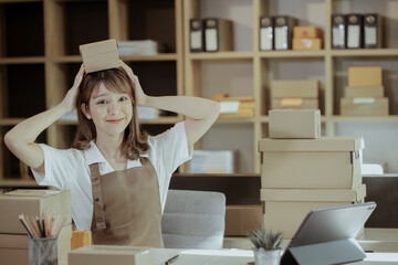 Startup small business woman or owner working with digital tablet, packing goods for delivery to customer, Online shopping and digital market concept.