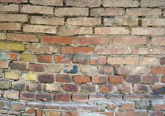 Old brick wall. We see very large bricks and crumbling joints.