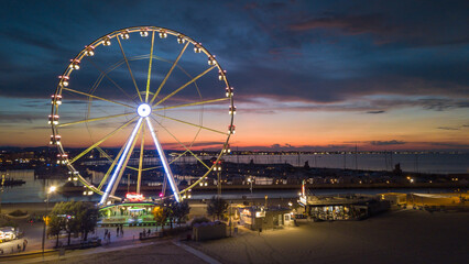 Italy, September 2022: view of the ferris wheel of Rimini with all the colored lights near the beach of the Riviera Romagnola