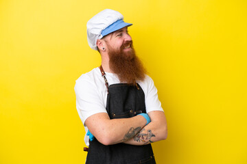 Fishmonger wearing an apron isolated on yellow background with arms crossed and happy