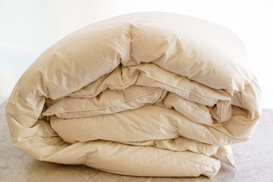 白いタンスに収納した折り畳んだ羽毛布団