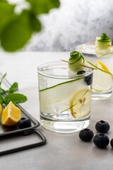 Refreshing detox water, drink with cucumber, blueberries and lemon. Healthy eating, healthy lifestyle concept. Bright background.