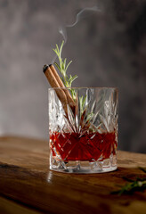 Bourbon cocktail glass with rosemary, old fashion cocktai ldrink, moody background