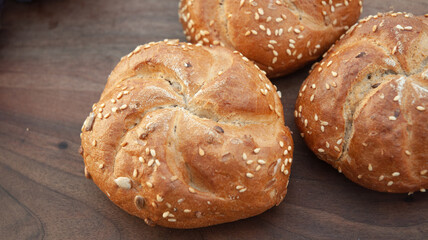 Buns with seeds on a wooden table.