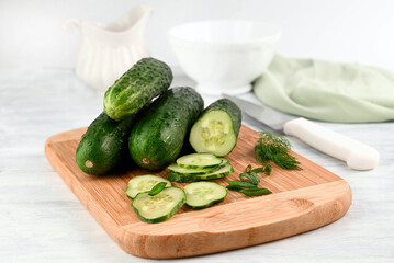 Blurred image of cucumbers and greens for salad preparation.