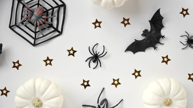 Halloween background with black bats, spiders, pumpkin and stars. Modern Holiday design. Halloween party border spinning on white. Flat lay, top view, copy space. Thanksgiving fall trendy decoration.