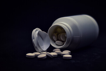 Tabletten - Medikamente - White medical pills or tablets with bottle on black background. - with...