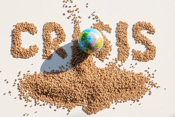 Word crisis from wheat grains, bread slices and small terrestrial globe. The concept of problems...