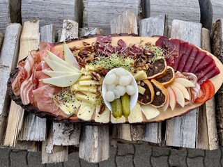 Typical Grisons snack plate containing dried meat and cheese specialities, pear bread served on...