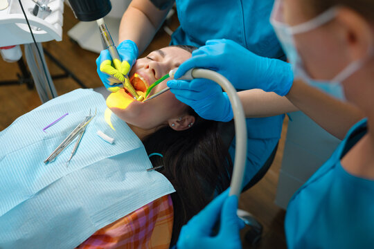 Dentist uses photopolymer lamp to cure carious teeth of the patient