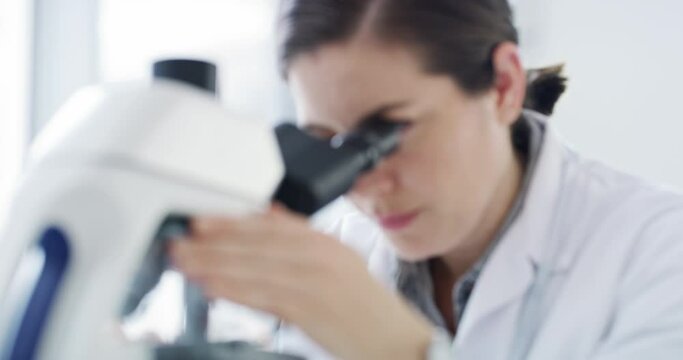 Scientist, microscope and forensic science of a woman working in research lab for a new discovery. Serious female expert in forensics experiment at work looking at particles and samples for results.