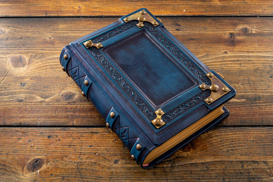 Rich Decorated Navy Blue Leather Book Captured On Wooden Table.