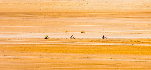 People cycling through a desert in Saudi Arabia.