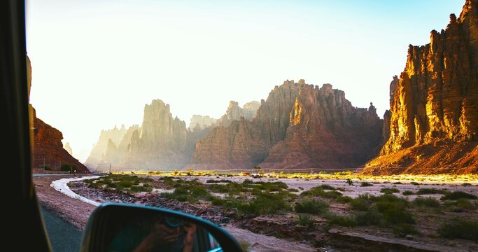 A valley of steep cliffs at sunrise. An image viewed from a car window at Wadi Disah, Saudi Arabia.