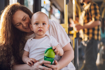 Mother and her child riding in a bus during a day.