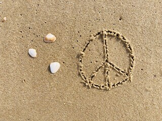 on the beach the peace symbol is carved into the smooth sand
