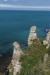 Rock fromation on the chalk cliffs of Etretat on a sunny day with turquoise colored sea water, Etretat, Normandy, France