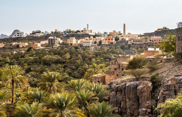 View of mountain village Misfat Al Abriyeen surrounded by the garden with date palms, Sultanate of...