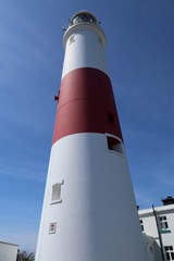 Looking up at the distinctive red and white striped lighthouse at Portland Bill in Dorset, England