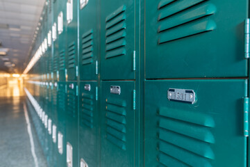 Green metal lockers along a nondescript hallway in a typical US High School.  No identifiable...