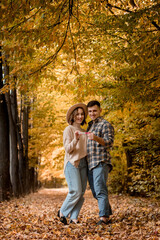 Fototapeta premium Loving husband and wife in the autumn park holding a positive pregnancy test. Waiting for a new life