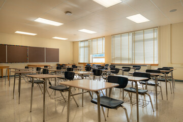 Example of an empty nondescript US High School Classroom with desks, Window and black board.
