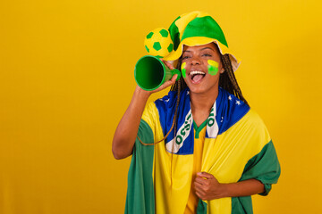 black woman young brazilian soccer fan. using phone pick up to announce something.