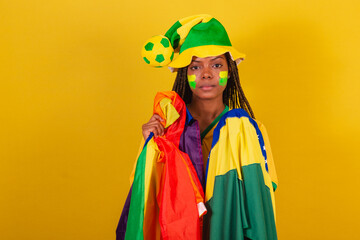 black woman cheerleader, holding brazil flag and lgbt flag, lgbt pride, diversity. female empowerment.
