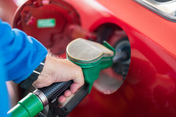 Man refueling his car with gasoline pump. To simulate the high costs of fuel , pollution and energy...