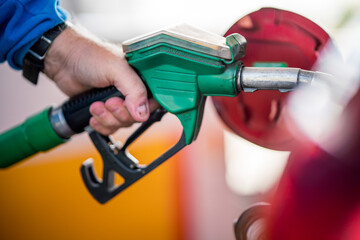 Man refueling his car with gasoline pump. To simulate the high costs of fuel , pollution and energy...