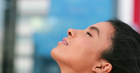 African american woman looking to the sky opening eyes feeling hope and smiling