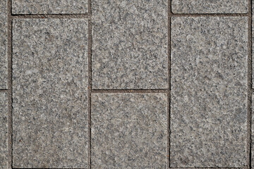 Rectangular gray cubes, equal sizes, straight, cut stones, edges on top, structure of split cubes, gaps between cubes with dark sand