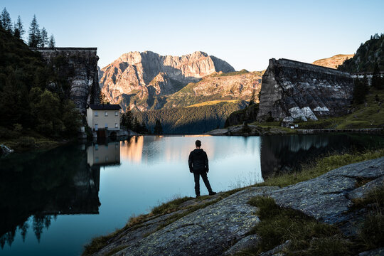 A hiker contemplates the view on Mount Presolana from the ruins of Gleno Dam, in the Orobie Alps, Northern Italy
