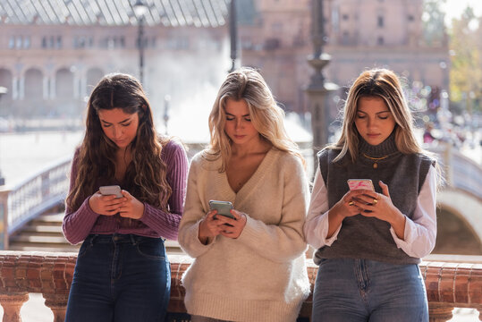 Women browsing smartphones in city
