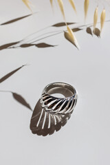 Silver ring on white background in natural light.